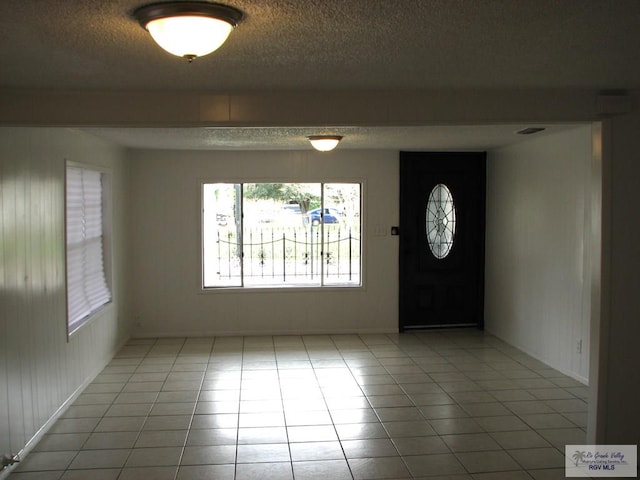 tiled entryway with a textured ceiling and visible vents