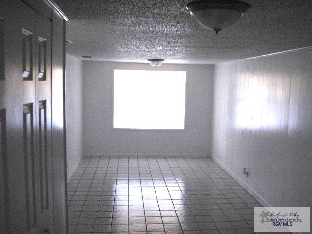 unfurnished room featuring a textured ceiling