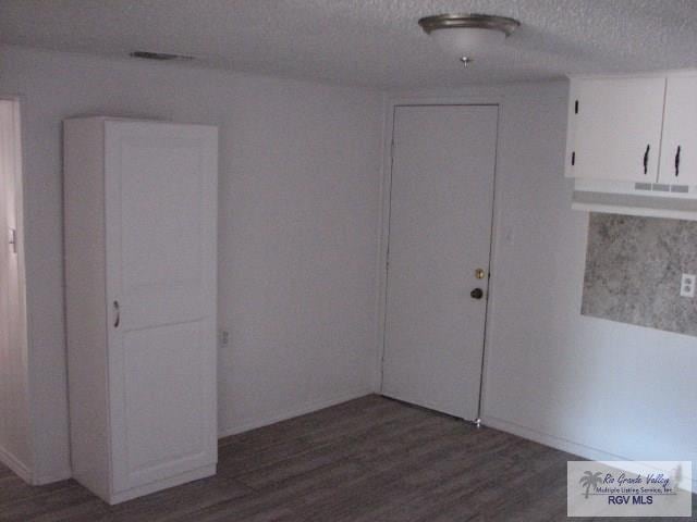 spare room with a textured ceiling and wood finished floors