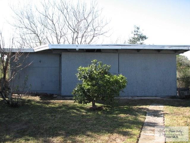 view of property exterior with a lawn and stucco siding