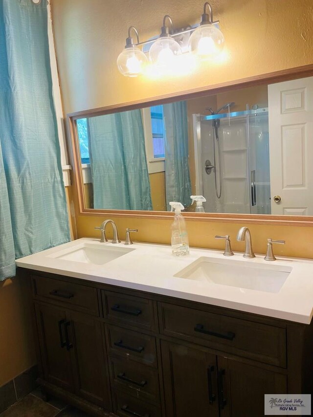 bathroom with tile patterned floors, vanity, and walk in shower