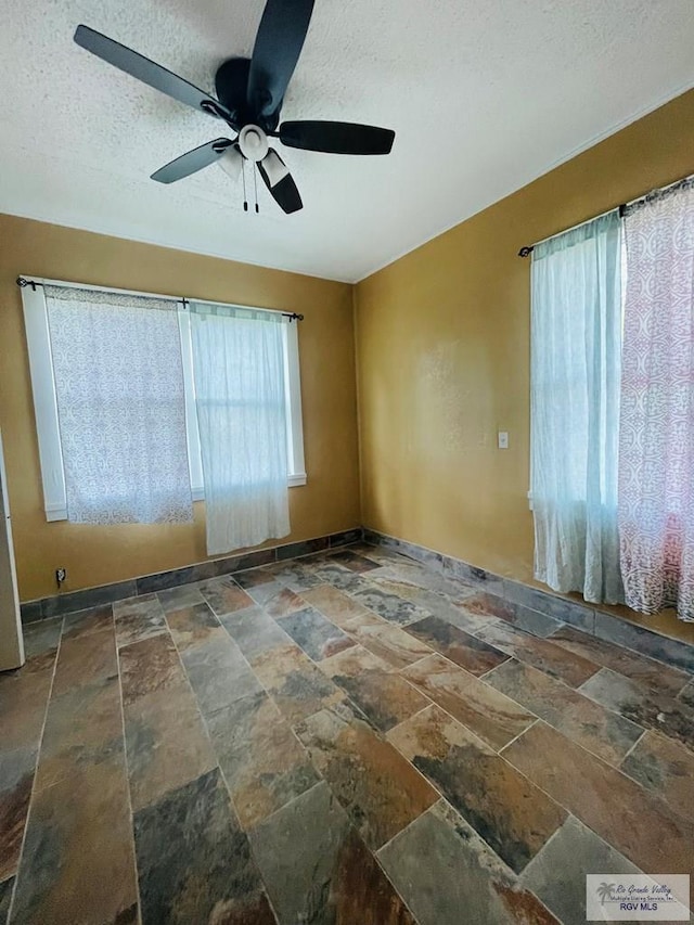 spare room with ceiling fan and a textured ceiling