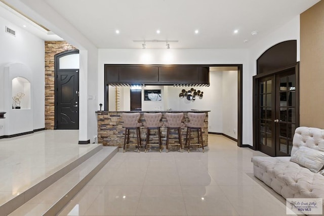 2360 Deer Run Cir, Brownsville, TX 78521 - dining space featuring bar area, light tile patterned floors, french doors, recessed lighting, and baseboards