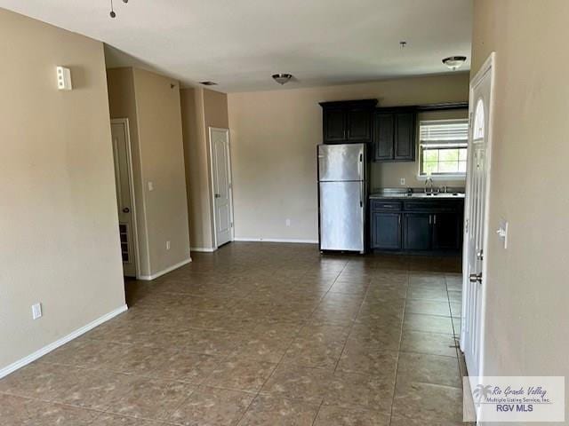 kitchen with stainless steel refrigerator, ceiling fan, and sink