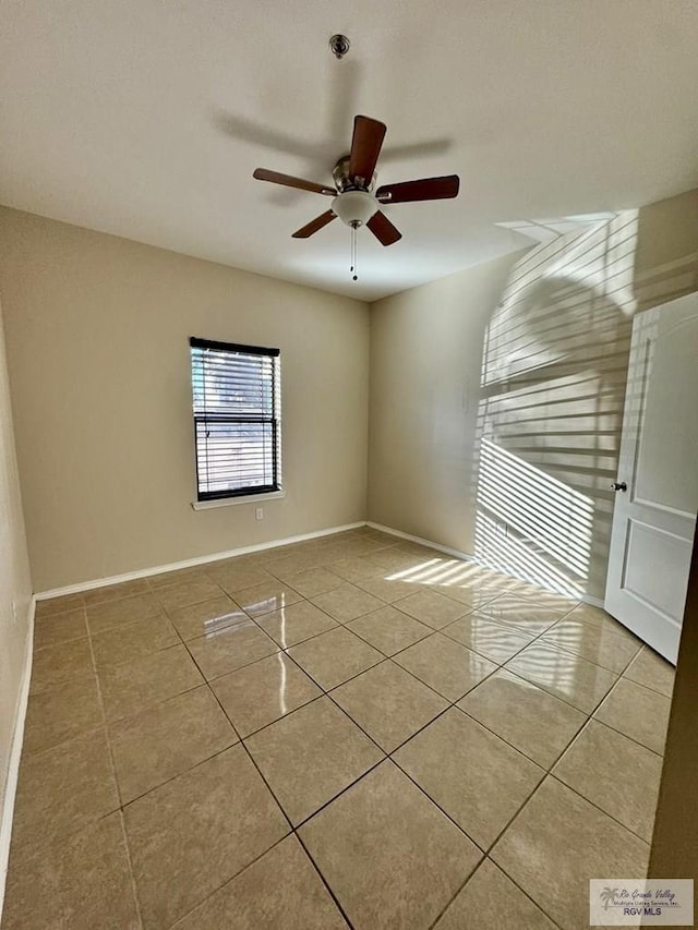 tiled empty room featuring ceiling fan