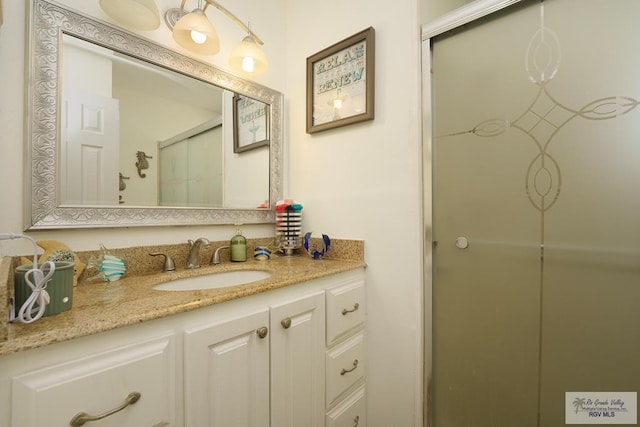 bathroom with vanity and a shower with shower door