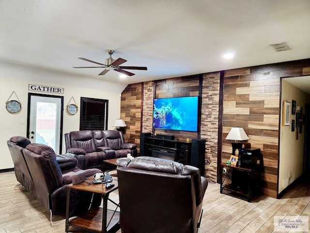 living room featuring wooden walls and ceiling fan