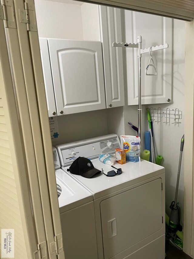 clothes washing area with cabinet space and separate washer and dryer