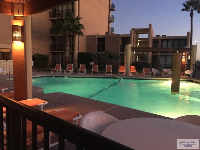 pool with a patio area and fence