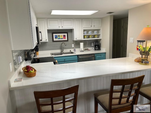 kitchen featuring tasteful backsplash, visible vents, appliances with stainless steel finishes, a sink, and a peninsula