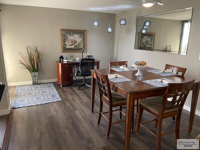 dining space with baseboards and dark wood-style flooring