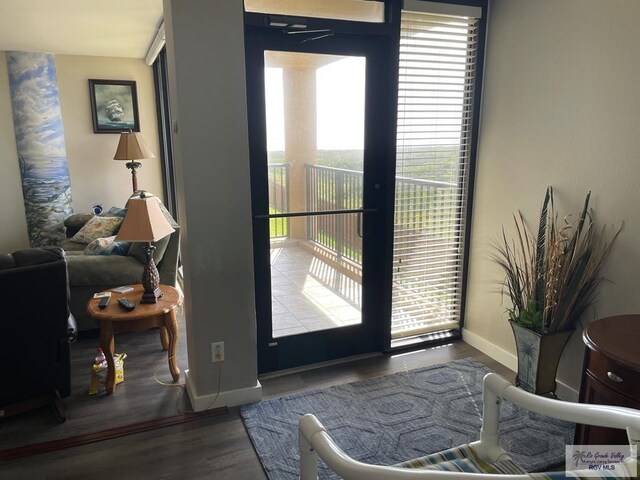 doorway to outside with baseboards and wood finished floors