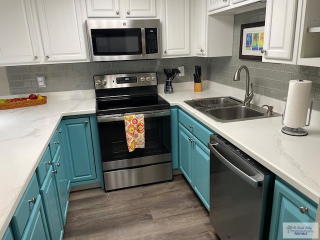 110 Padre Blvd Unit 202, South Padre Island, TX 78597 - kitchen featuring appliances with stainless steel finishes, white cabinets, blue cabinets, and dark wood-type flooring