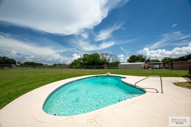 view of swimming pool featuring a patio area and a lawn