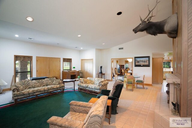 living room with light tile patterned floors, a healthy amount of sunlight, and vaulted ceiling