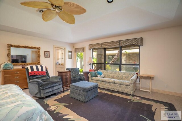 living room with carpet flooring, a raised ceiling, and ceiling fan