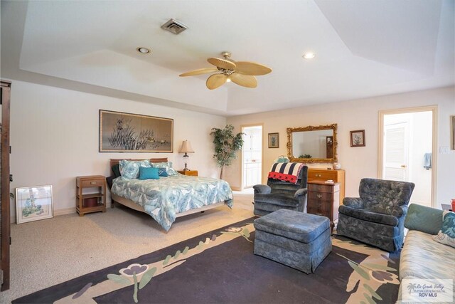 bedroom with carpet flooring, ceiling fan, and a raised ceiling