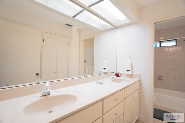 full bathroom with vanity, toilet, and tiled shower / bath