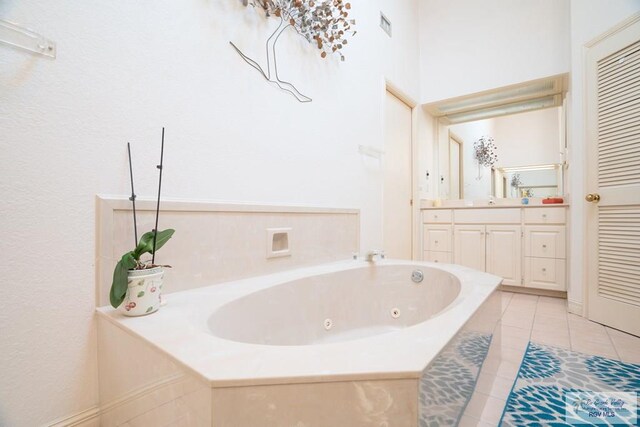 bathroom featuring vanity, a tub to relax in, and tile patterned floors