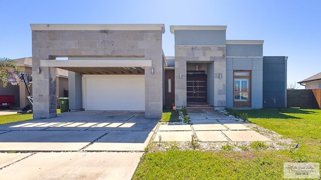 modern home featuring a garage, driveway, a front lawn, and fence