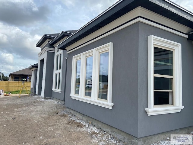 view of property exterior featuring fence and stucco siding