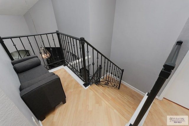 stairway featuring a towering ceiling and hardwood / wood-style flooring