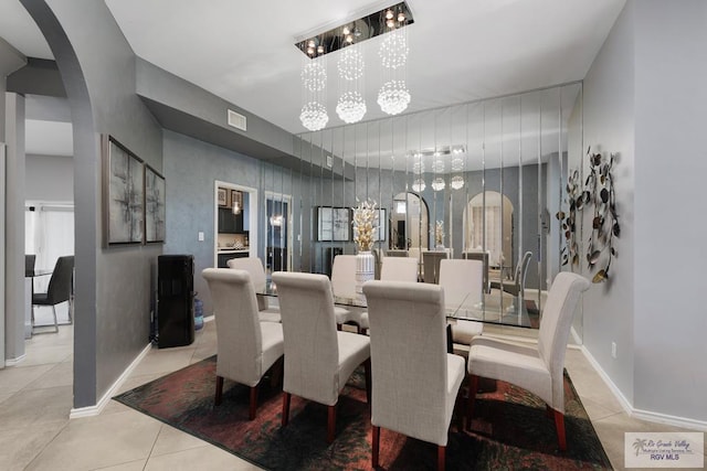 tiled dining room with an inviting chandelier