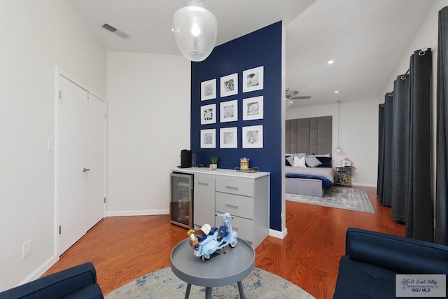 living room with wood-type flooring, wine cooler, and ceiling fan