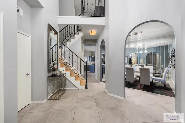 tiled foyer with a towering ceiling