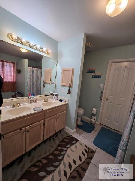 bathroom featuring tile patterned floors, vanity, and toilet