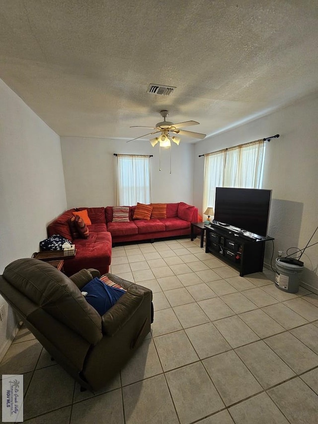 tiled living room featuring a textured ceiling and ceiling fan