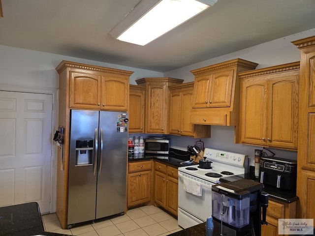 7301 Alabama Pine St, Brownsville, TX 78535 - kitchen with stainless steel appliances, brown cabinets, light tile patterned floors, and dark stone countertops