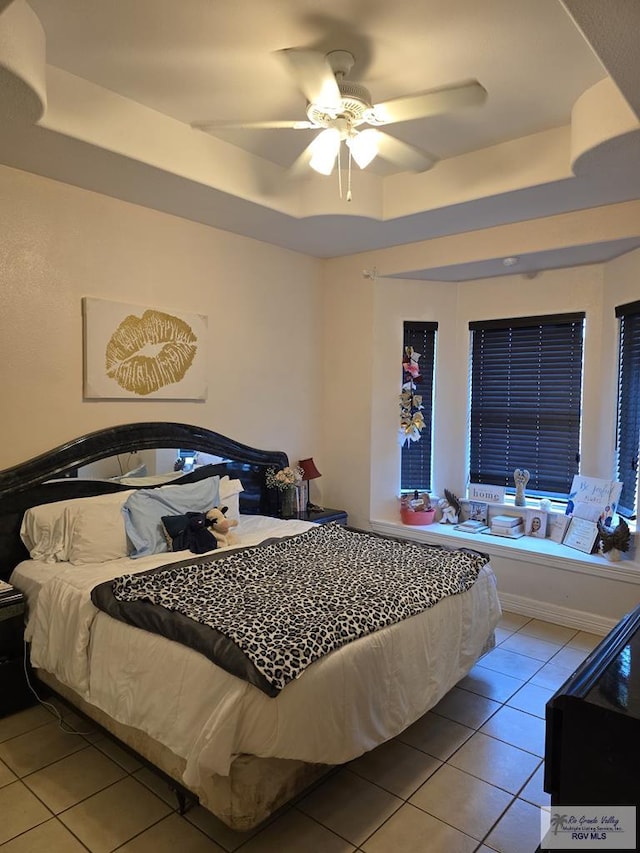 7301 Alabama Pine St, Brownsville, TX 78535 - bedroom featuring a tray ceiling, tile patterned flooring, and a ceiling fan