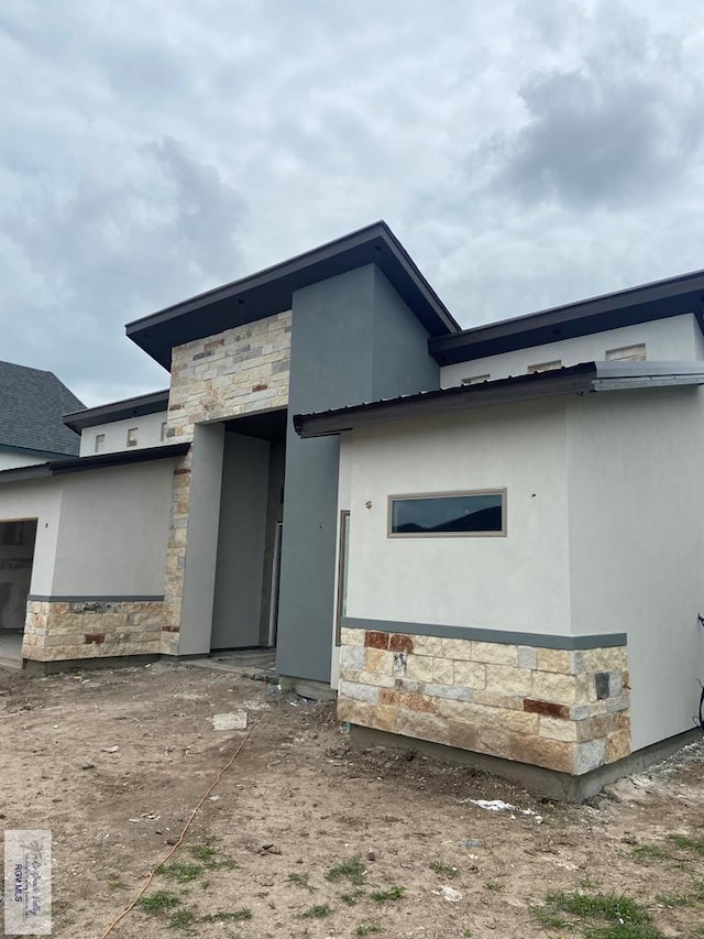 exterior space with stone siding and stucco siding