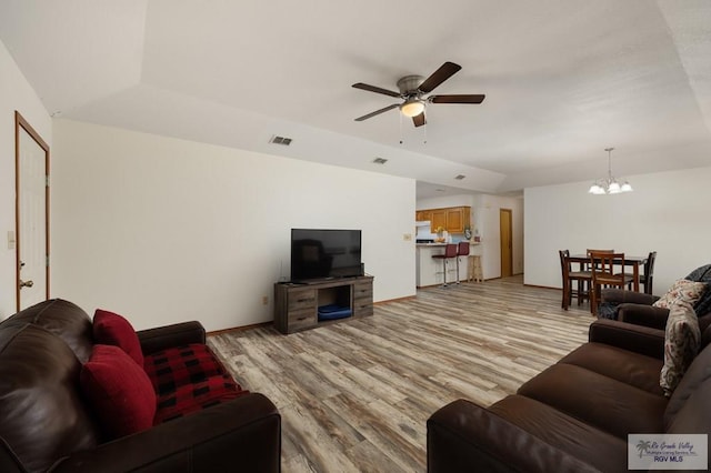 6246 Camelot Dr, Harlingen, TX 78550 - living room featuring a chandelier, a ceiling fan, light wood finished floors, and vaulted ceiling