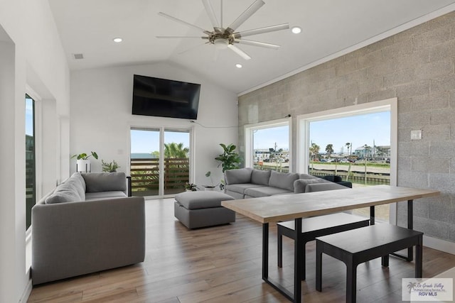 living room featuring ceiling fan, wood-type flooring, and vaulted ceiling