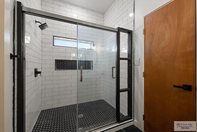 bathroom featuring a shower with door