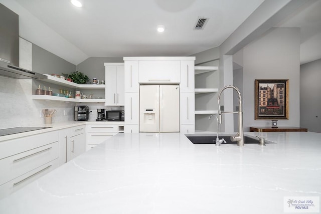 kitchen featuring open shelves, visible vents, a sink, black appliances, and wall chimney exhaust hood