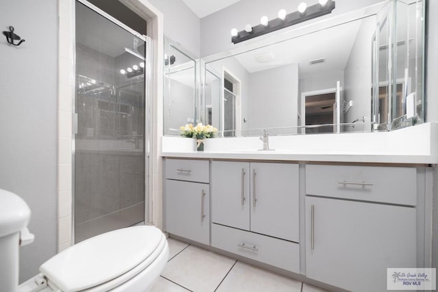 full bath featuring toilet, tile patterned flooring, a shower stall, and vanity