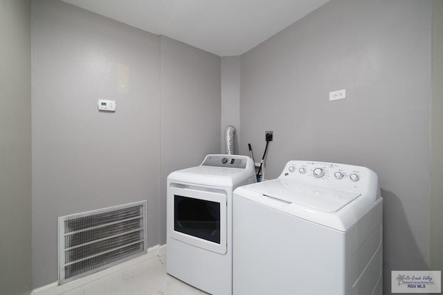 laundry room featuring laundry area, visible vents, washer and clothes dryer, and marble finish floor