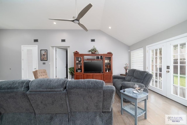 living room featuring light wood finished floors, visible vents, vaulted ceiling, and french doors