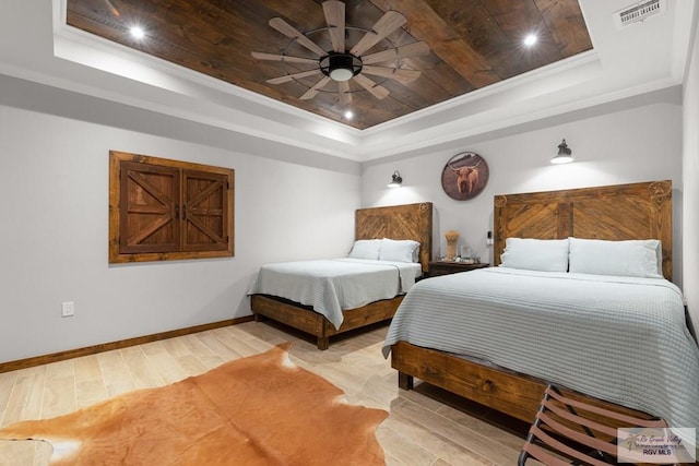 bedroom with a tray ceiling, ceiling fan, crown molding, and wood-type flooring