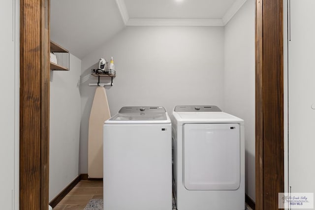 washroom with crown molding, light hardwood / wood-style flooring, and washer and dryer