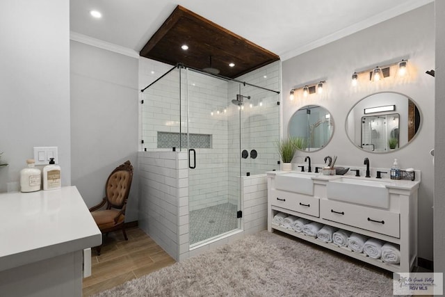 bathroom with vanity, ornamental molding, a shower with shower door, and hardwood / wood-style flooring