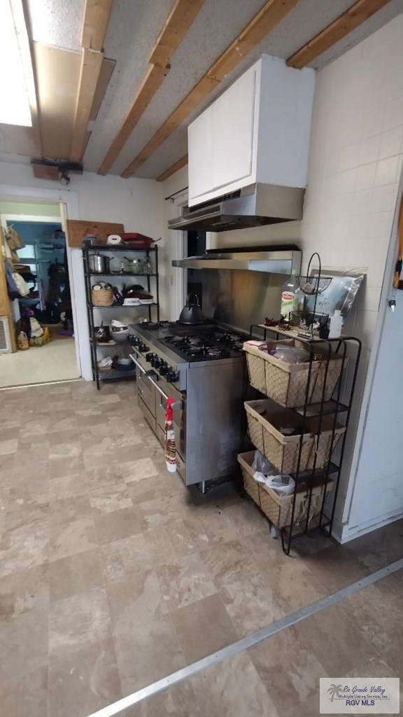 515 Honeydale Rd, Brownsville, TX 78520 - kitchen featuring white cabinetry, double oven range, and extractor fan