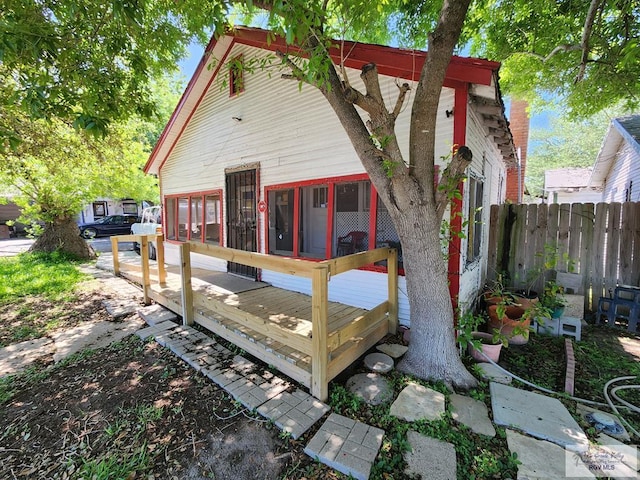 back of house with fence and a wooden deck