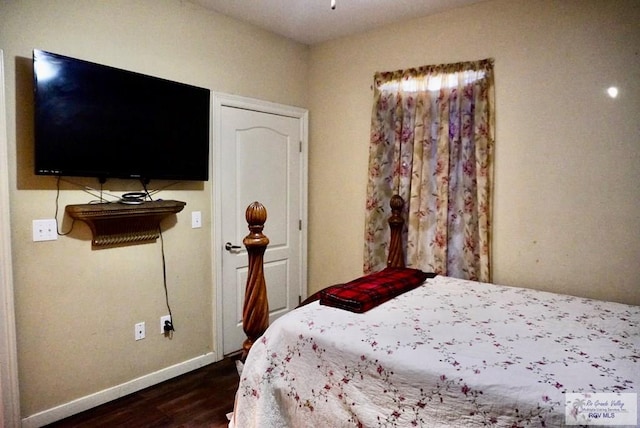 bedroom with dark hardwood / wood-style floors