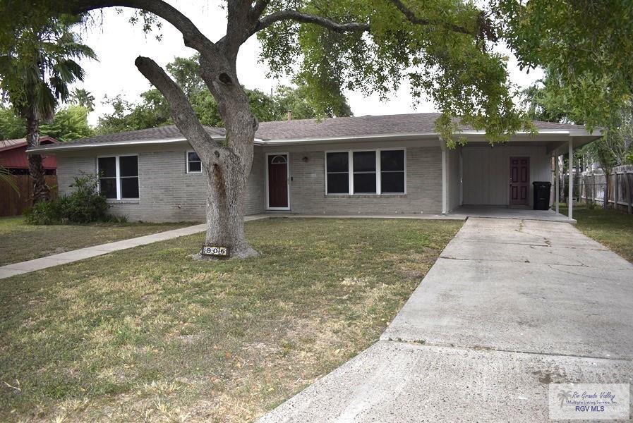 ranch-style house with a carport and a front lawn