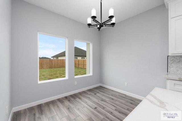 2023 Peace Dr # 23, La Feria, TX 78559 - unfurnished dining area with a chandelier, light wood-style flooring, and baseboards