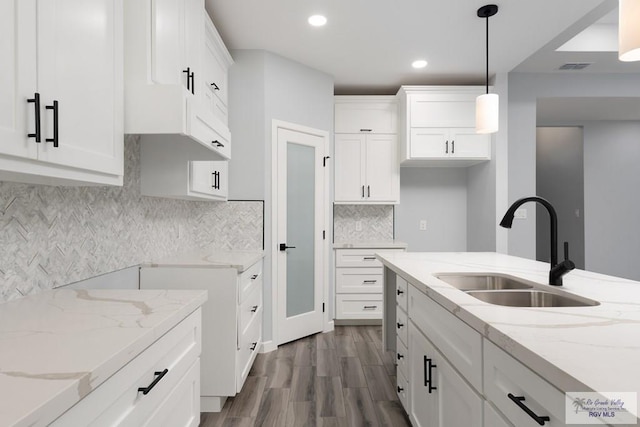 2023 Peace Dr # 23, La Feria, TX 78559 - kitchen with a sink, dark wood-type flooring, light stone countertops, white cabinets, and recessed lighting